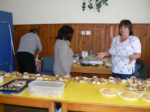 Členky OZ Lutilienka pripravujú na&nbsp;tácky prinesené koláčiky na&nbsp;pohostenie v&nbsp;príležitostnej kaviarničky